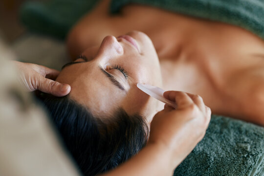 Woman receiving gua sha therapy at spa