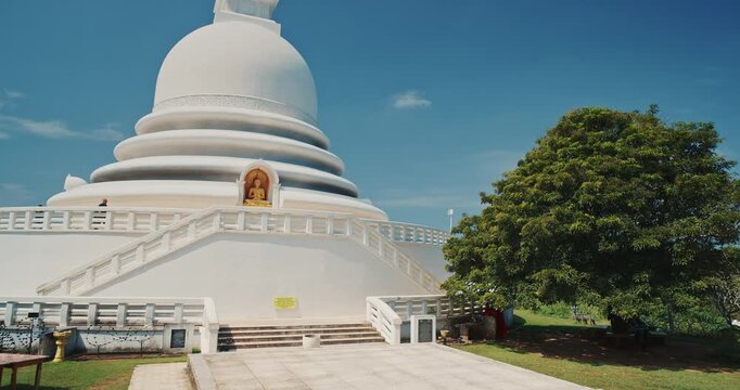 Sri Lanka, Unawatuna. Japanese Peace Temple In Rumassala, Galle, Sri Lanka. Monks walking around Famous landmark and cultural sacred place. View of the Japanese built Buddhist Temple Peace Pagoda at