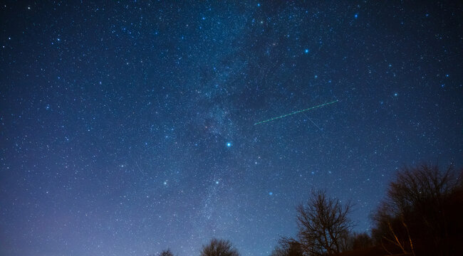 Milky way stars and rural countryside silhouettes.