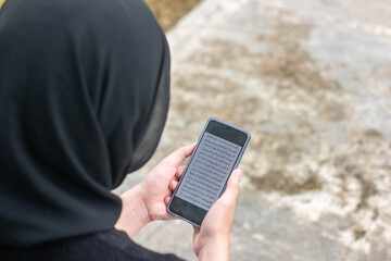 Muslim Woman Wearing Hijab Reading Quran on Smartphone Outdoors Communication Concept