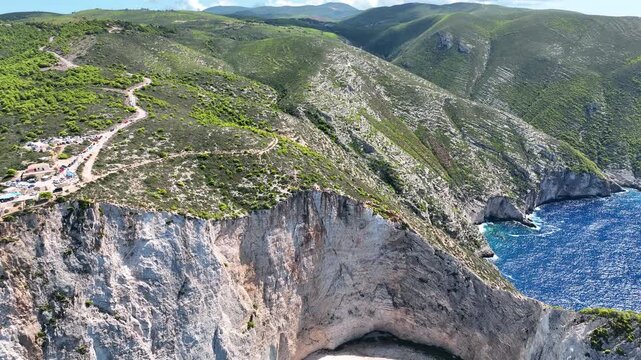 Aerial drone view of famous Navagio Shipwreck Beach with turquoise sea water and boats in Zakynthos island, Greece on a bright sunny da
