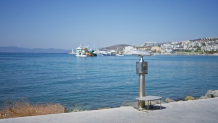 Coastal promenade and concrete forecourt with a defocused harbor, distant hillside town and soft shallow sea outdoor  background backdrop copyspace calm. © Krakenimages.com