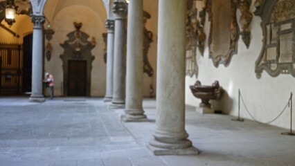 Soft blurred museum corridor with stone columns, vaulted arcade and tiled floor, defocused interior museum; background backdrop copyspace calm.