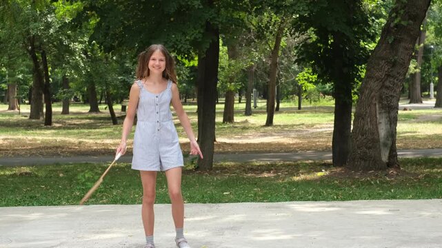 Young girl play badminton in green park on sunny day. Concept of active lifestyle and summer outdoor recreation.