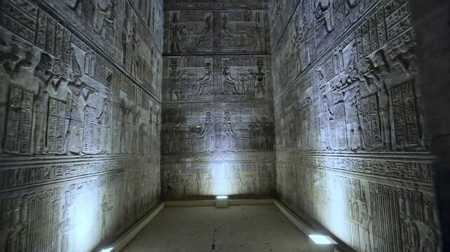 Dendera temple interior sanctuary with illuminated hieroglyphic walls and ritual reliefs in Egypt, ancient sacred chamber with dramatic lighting on carved sandstone surfaces.