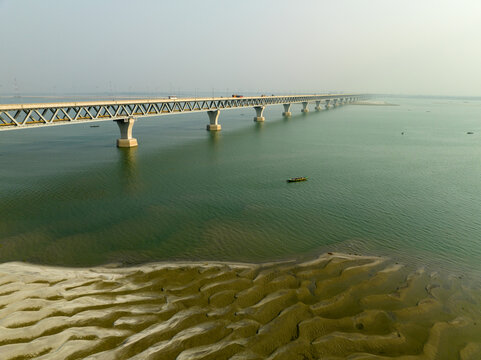 Aerial view of the Padma Multipurpose Bridge stretches across the shimmering water, connecting both sides of the river, Mawa, Dhaka Division, Bangladesh.