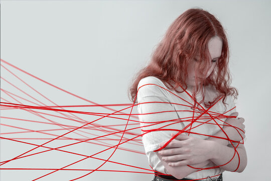 Teen girl tangled in red lines, concept of manipulation, pressure and judgment, personal boundaries violated, anxiety and avoiding conflict in social environment.