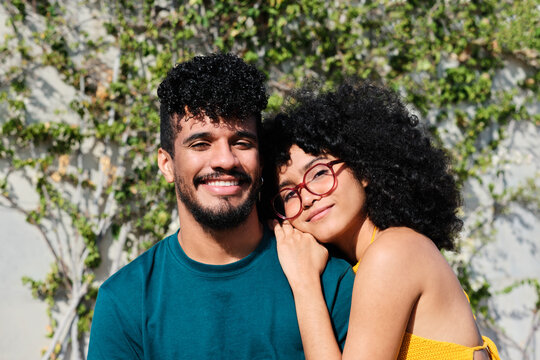 headshot of Smiling young hispanic couple sharing happy casual moment outdoors