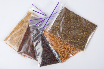 Assortment of seeds in plastic bag on white background, top view