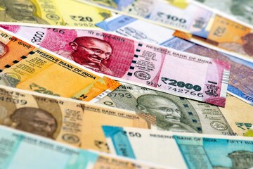 Obraz premium Indian rupee money bills pile on table. India banknotes of INR currency close up.