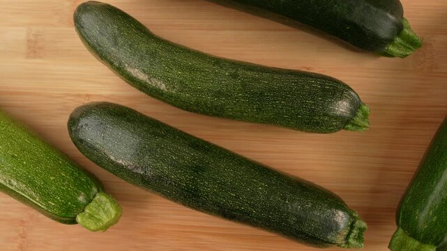 Fresh green zucchini on wooden background top view.
