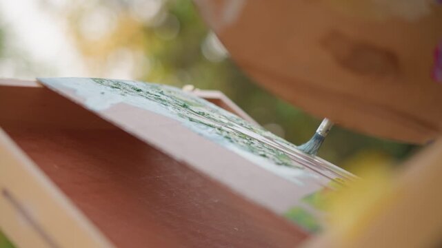 outdoor easel canvas closeup sunlit bokeh, empty primed surface with subtle sketch marks, gesso texture on wooden frame, urban park backdrop, warm autumn light, street art setup for painting study