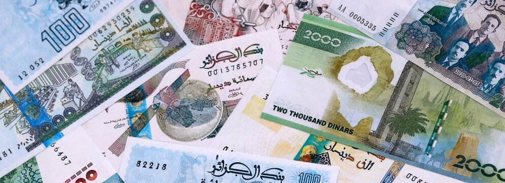 Algerian dinar money bills pile on table. Algeria banknotes of DZD currency close up.