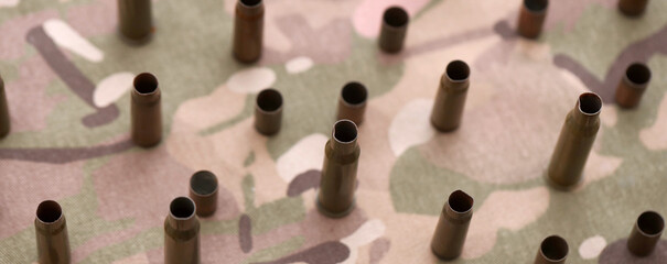 Obraz premium Big amount of shells cartridges from assault rifle bullets on old camouflage fabric