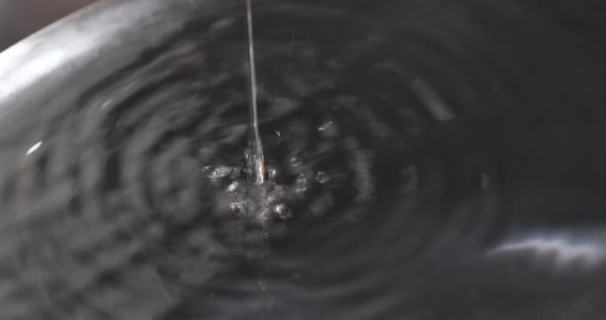 水道蛇口から水が洗い桶に落ちる様子