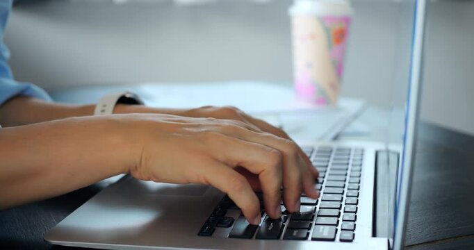 Fast data entry at desk. Focused fingers typing rapidly for office tasks efficiently. Keyboarding skills demonstrated while entering data swiftly beside cup of coffee in professional setting