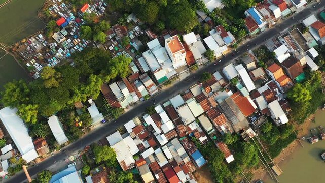 Drone shot of Chau Doc village with clustered rooftops, greenery, and riverside setting in Vietnam. Urban and natural landscape captured from above.