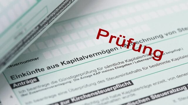 Ein Formular zur Einkommensteuer wird vom Finanzamt mit einem Stempel markiert - FOTOMONTAGE