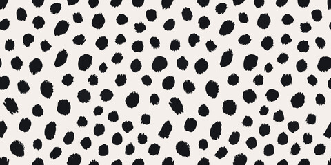 A seamless pattern of irregular black spots on a cream background © Tarun