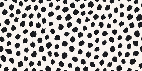 A seamless pattern of irregular black spots on a cream background