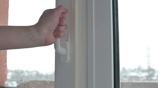 Demonstrating the process of opening and securing a window. Broken plastic door handle rotates 360 degrees, demonstration of broken mechanism