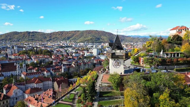 Aerial view of the Grazer Uhrturm clock tower standing majestically over the city's landscape, a blend of history and nature, Graz, Styria, Austria.