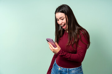 Fototapeta premium Young woman receiving exciting news on smartphone
