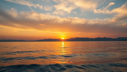 Fototapeta premium Serene sunset over calm sea with colorful clouds on horizon, horizontal image 