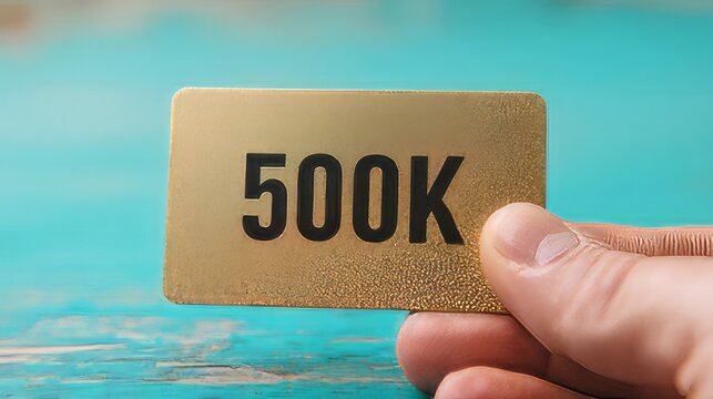 Celebration milestone card recognizing an achievement of 500,000 followers, subscribers, or views. Hand holding 500k shout out subscribers  golden card thank you. 