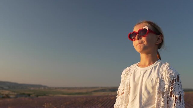 Child sunglasses lavender field happy little girl wearing white lace cardigan pouts and blows a kiss during sunny summer vacation