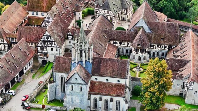 Aerial view of Bebenhausen Monastery's red-tiled roofs and half-timbered buildings, a tapestry of history and nature's embrace, Tubingen, Baden-Wurttemberg, Germany.
