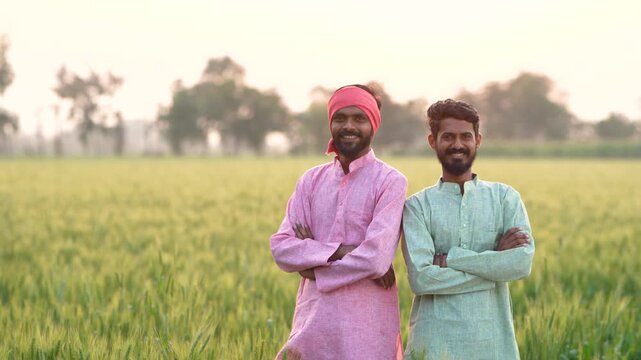Two indian farmer standing at wheat agriculture field	