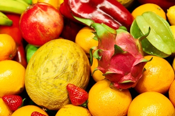 Fresh tropical fruits and vegetables creating colorful background