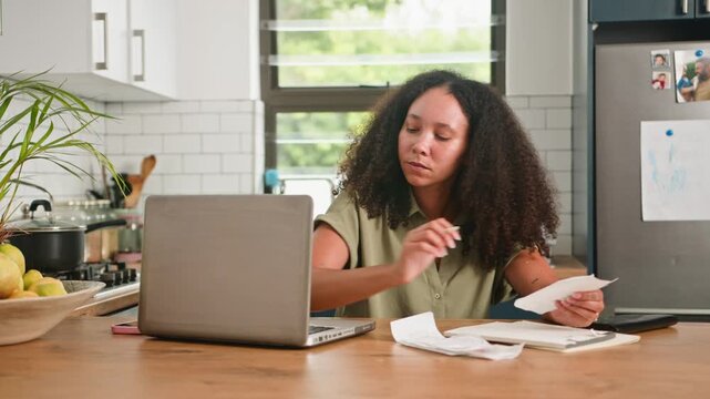 Stressed Woman Managing Household Finances and Budgeting Expenses at Her Kitchen Table