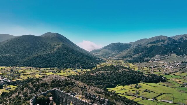 Aerial view of rugged mountains meeting green valleys, under a clear blue sky, offering a scenic contrast, Askifou, Chania, Greece.