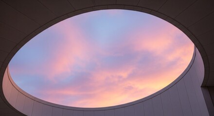Obraz premium A circular window with a view of a colorful sky, featuring a mix of pink, blue, and purple hues, set against a white background.