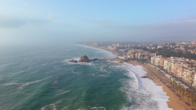 Aerial view of blanes coastline with stormy sea and fog