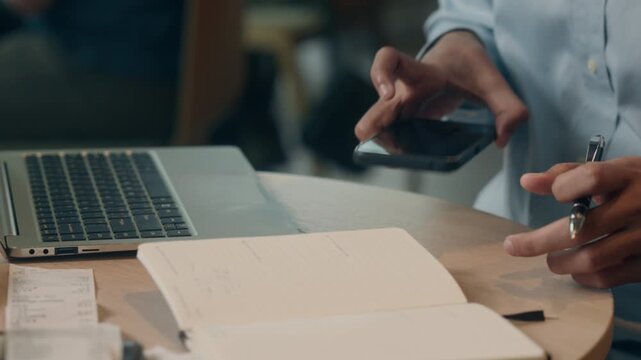 Arabian business man typing laptop answer mobile phone call in cafe Indian businessman male guy entrepreneur working computer pc cyberspace talking smartphone discuss job news visitor in coffeehouse