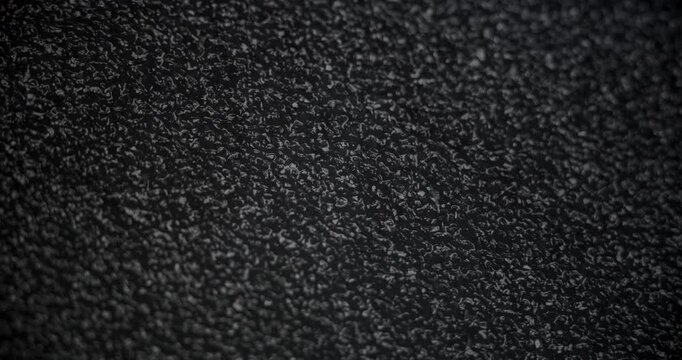 Black Rough Texture Background. A slow panning footage across a deep black grainy surface revealing tactile depth through gentle shadow shifts 