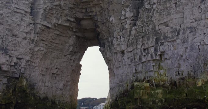 Wide Tilting up shot of the Kingsgate Arch chalk stack with Kingsgate bay in background.