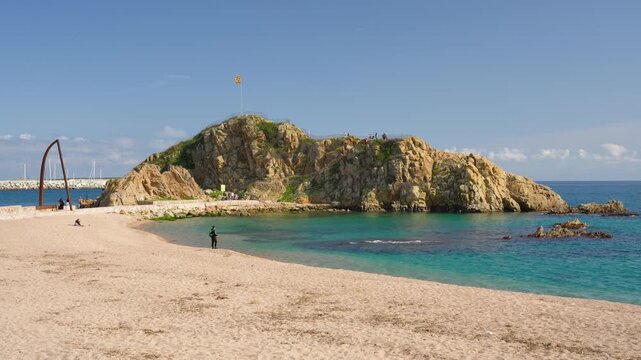 Sa palomera rock on sandy blanes beach in costa brava