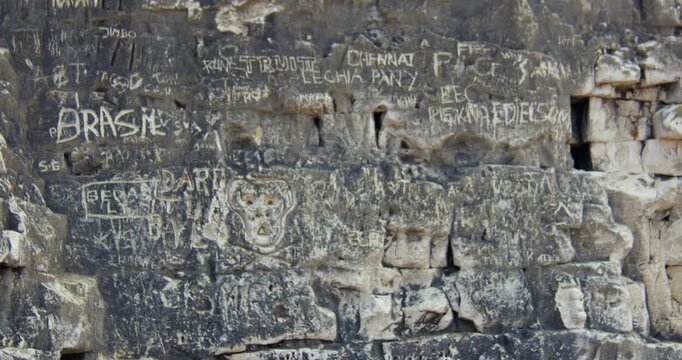 Shot zooming in of graffiti names Carved into the chalk cliffs at botany Bay Beach at low tide. At marine Drive, Broadstairs