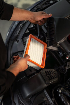 Engine air filter replacement car auto shop maintenance mechanic hands open hood automotive service routine maintenance professional