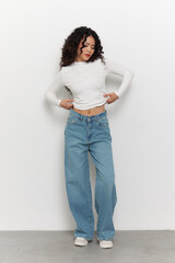 Stylish Model Showcasing Casual Fashion in Comfy Loose-Fitting Jeans and Elegant Long-Sleeve Top Against a Clean Background