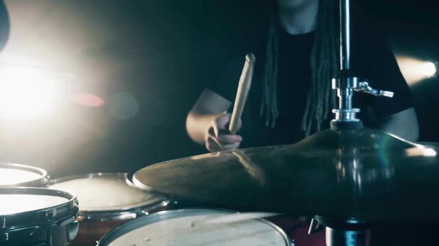 drummer in a black suit playing a drum cymbal at a concert Bright Performance of a rock band Musician hands drumming metal percussion instrument at