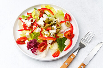 Closeup lettuce salad with tomato red pepper feta and olives concept for healthy diet or gourmet restaurant photography