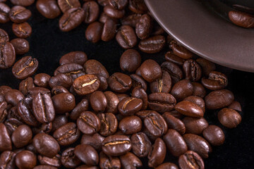 Obraz premium Close-up view of roasted coffee beans on a dark surface