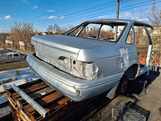 Part of a car body. The body of a grey car sawn in half