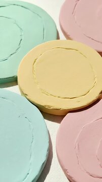 Circular wax seals in pastel colors mint green peach yellow and black arranged on textured fabric showcasing a vintage aesthetic for invitations and branding