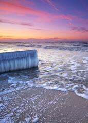Fototapeta premium icicle on the frozen winter pier in sunset light